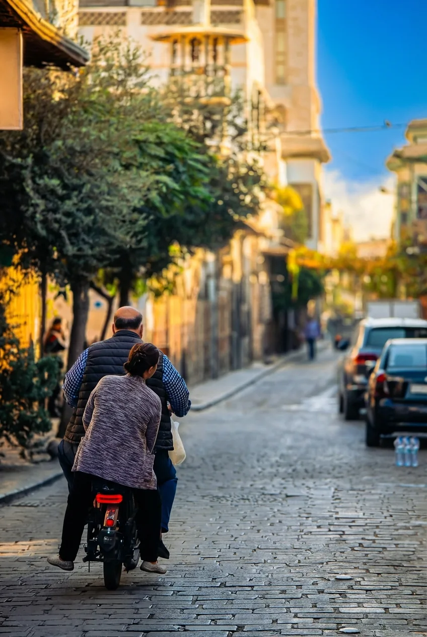رجل وامرأة على دراجة نارية في شارع حجري